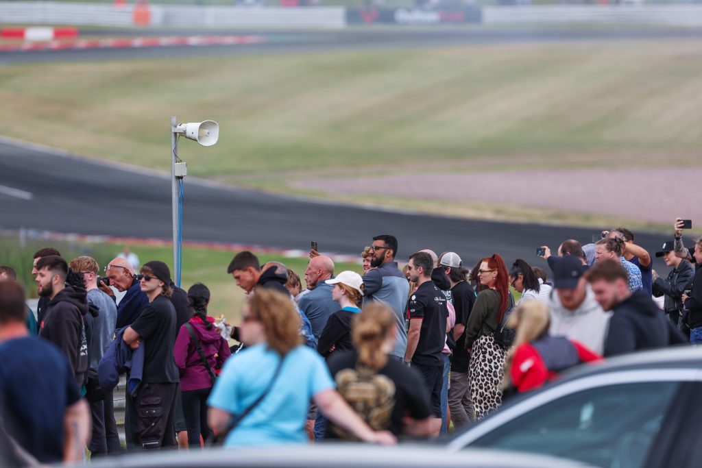 a large crowd of people watching near the track